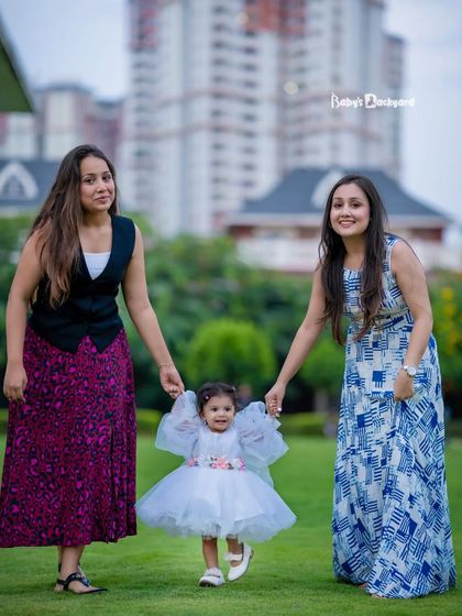 A little girl enjoys a walk in the park, lovingly guided by two important women in her life. Our photoshoots celebrate the entire family circle.