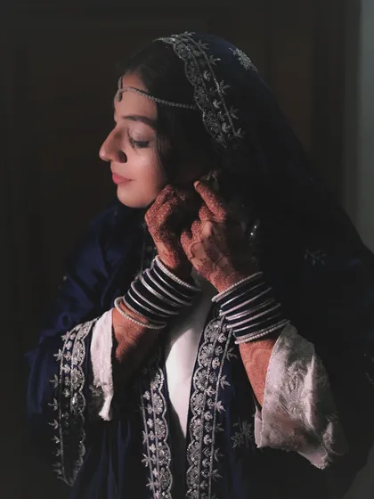 A quiet moment of reflection for the bride as she adjusts her jewelry. I used soft, natural light to create this intimate bridal portrait, highlighting the intricate details of her attire and henna.