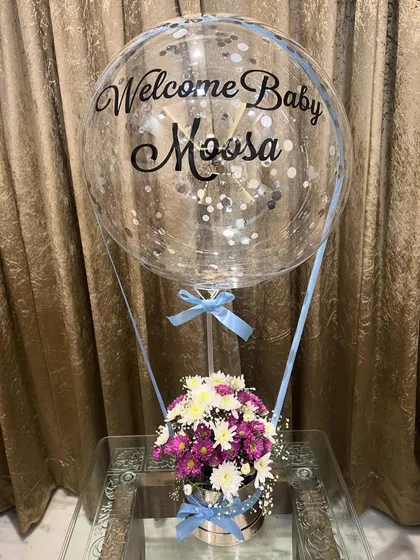 A full view of the baby boy hot air balloon gift. The combination of fresh flowers in the silver box and the floating personalized balloon makes for a perfect congratulations gift.