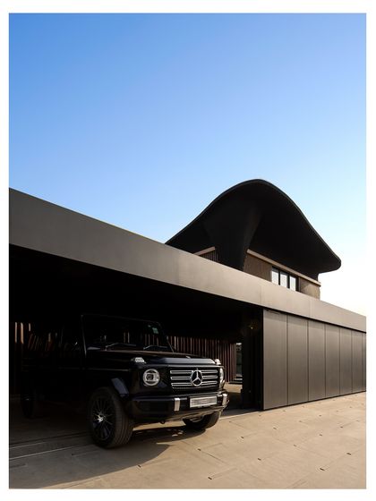 The covered parking at Residence Ondra is a key element of its privacy-focused design. A powerful G-Wagon is shielded from the elements, and the home's interior remains completely hidden from the road, a thoughtful solution for modern Indian living.