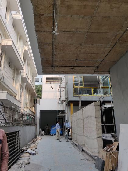 The same entryway during construction, showing the raw concrete ceiling and unfinished walkway before the final materials were installed.