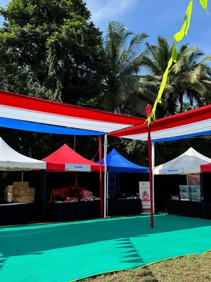 This image from Kukdukoo Pune shows the clean and organized layout I deliver. The setup features colorful overhead canopies and neatly arranged pagoda tents on a green turf, creating a welcoming environment for a family-friendly event.