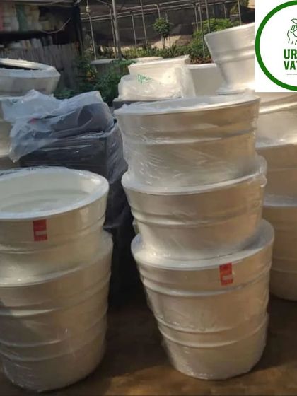 Stacks of large white plastic pots, ready for big planting projects.