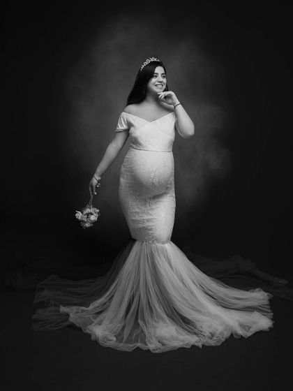 In this frame, we celebrate the beauty of motherhood in its purest form. A timeless monochrome portrait in a white lace mermaid gown.