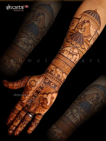 This bridal arm design features a doli scene at the top. It's a beautiful way to symbolize the bride's journey to her new home, surrounded by intricate traditional patterns.