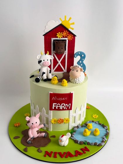 Welcome to Nivaan's farm. This delightful farm-themed cake features a red barn, a playful pig in a mud puddle, a cow, sheep, and other handcrafted animal friends, creating a charming scene for a third birthday.