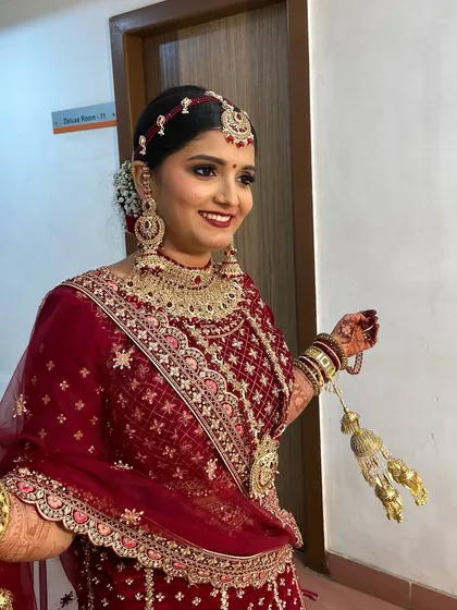 A radiant bride ready for her big moment. This classic bridal look features bold red lips and defined eyes, paired with a traditional floral bun to complete her stunning velvet lehenga ensemble.
