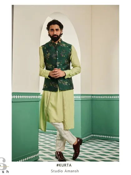 This ensemble is perfect for daytime celebrations like a mehendi or haldi ceremony. We paired a light green drape kurta with an emerald green bundi jacket featuring intricate floral embroidery, creating a look that is both fresh and regal.