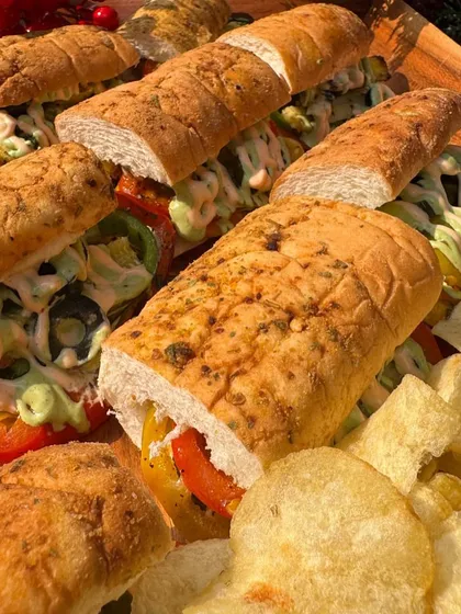 A platter of hearty sandwiches served with potato chips, perfect for a casual corporate lunch or daytime event.