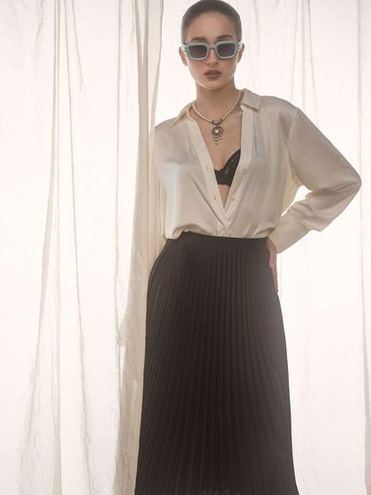 A chic and effortless look. The soft, diffused light from the side mimics natural window light, creating a gentle and sophisticated mood that complements the classic black and white outfit.