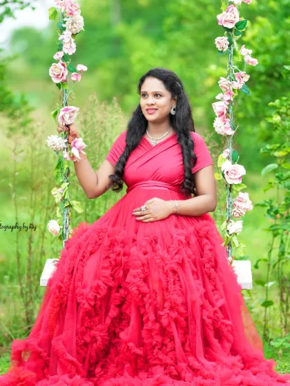 A beautiful solo portrait on our floral swing. The mother-to-be is wearing a vibrant red ruffled gown.