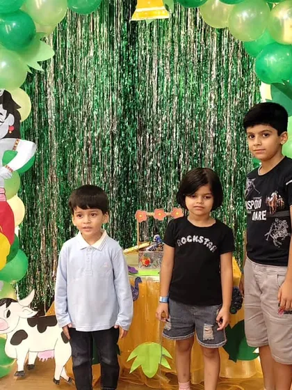 Three young boys pose together at our Janmashtami celebration, enjoying the festive environment we create for every occasion.