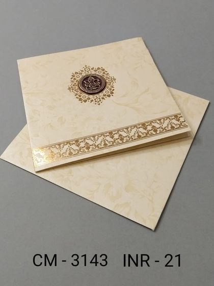 A simple and affordable cream-colored invitation with a central Ganesha emblem. The gold foil border adds a touch of elegance to this classic design.
