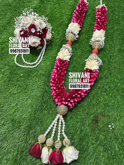 This wedding set includes a beautiful varmala made from red rose petals and white flowers, accented with golden beads. It comes with a matching hand bouquet for the groom, creating a perfectly coordinated look.