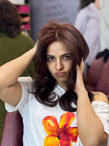 A fun, playful shot of the client enjoying her new reddish-chocolate hair. It's all about how the new color makes you feel.