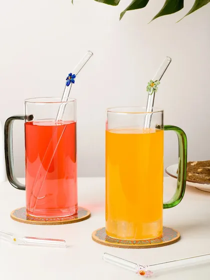 The same floral glass straws shown in use with colorful drinks. This lifestyle shot helps customers see the product in action.