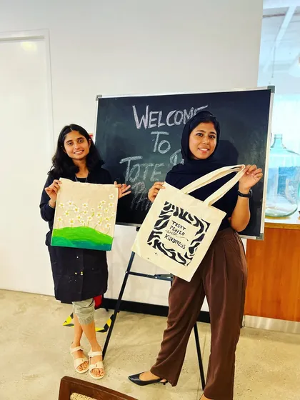 The best part of any workshop is seeing the proud smiles and the amazing final creations. These participants from a tote bag painting session are holding up their unique, hand-painted designs. Everyone leaves with a functional piece of art and a great memory.