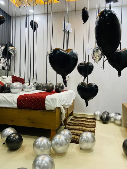 A detailed shot of the black heart-shaped foil balloons floating at eye level, part of a modern and stylish birthday room decoration.