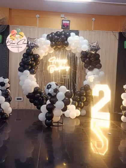 A football-themed second birthday with a black and white balloon ring and marquee number.