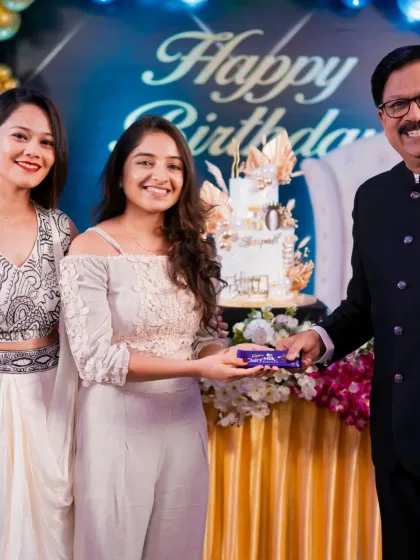 It's so rewarding to see my creations bring joy. Here I am with the happy client at his 60th birthday party, with the white and gold cake in the background.