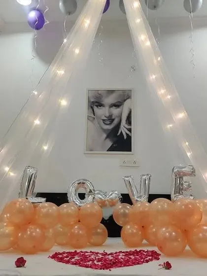 A close-up of the bed decoration, with the "LOVE" balloons and a classic Marilyn Monroe print in the background.
