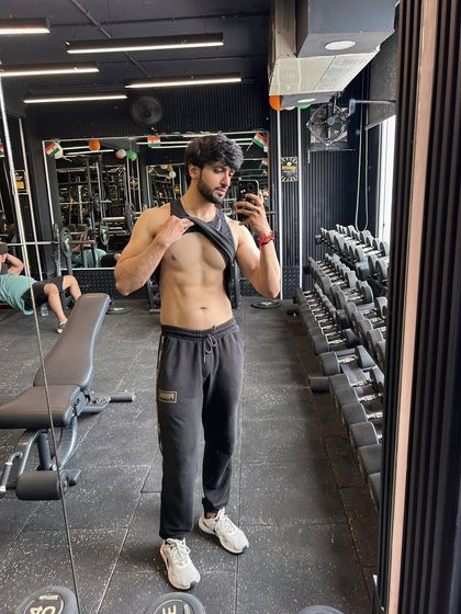 A mirror selfie in the gym showing core definition. The key to visible abs is a combination of targeted exercises and low body fat.