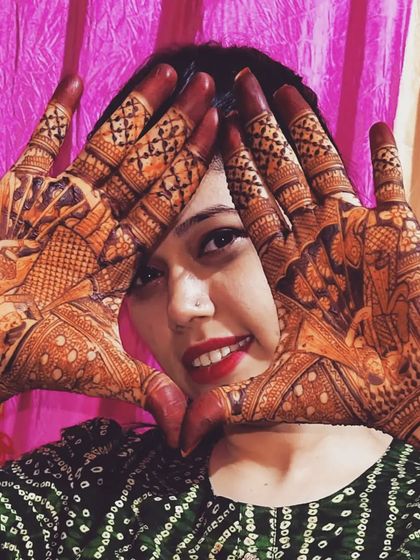 A happy bride showing off her full bridal mehndi stain.