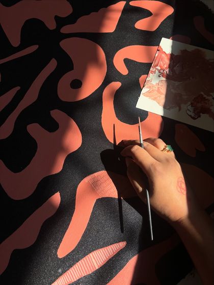 Painting an abstract pattern in the sunlight. The play of light and shadow on the canvas becomes part of the artwork itself during the creation process.