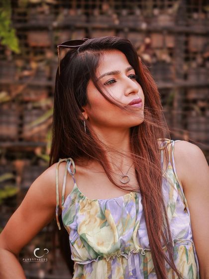 The wind catching her hair creates a beautiful sense of movement and life. This outdoor portrait feels dynamic and full of energy.