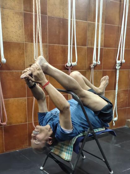 A reclining leg-stretch pose on a chair.