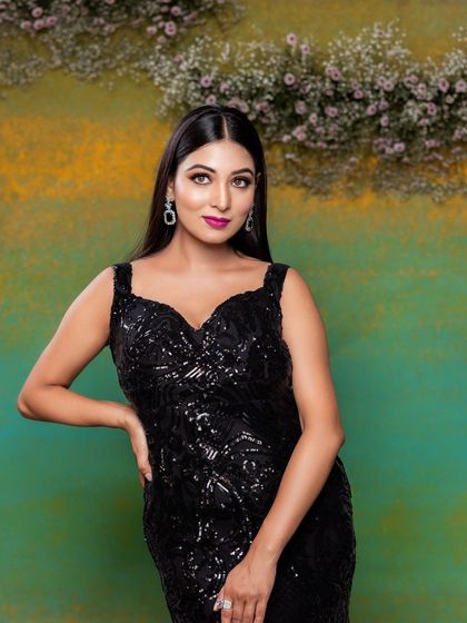 A full-length view of the stunning black sequin gown. The bold makeup provides the perfect contrast and completes this glamorous evening look.