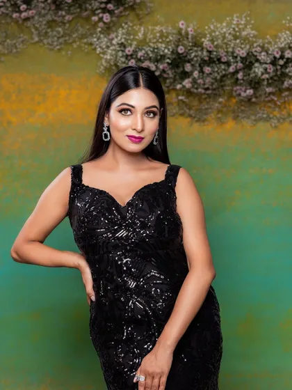 A full-length view of the stunning black sequin gown. The bold makeup provides the perfect contrast and completes this glamorous evening look.