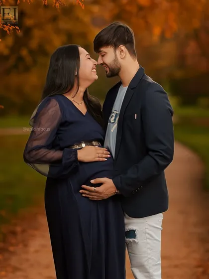 Capturing the shared joy and anticipation between partners. This outdoor couple's maternity portrait uses the warm tones of an autumn park to highlight the couple's close bond and excitement for their new arrival.