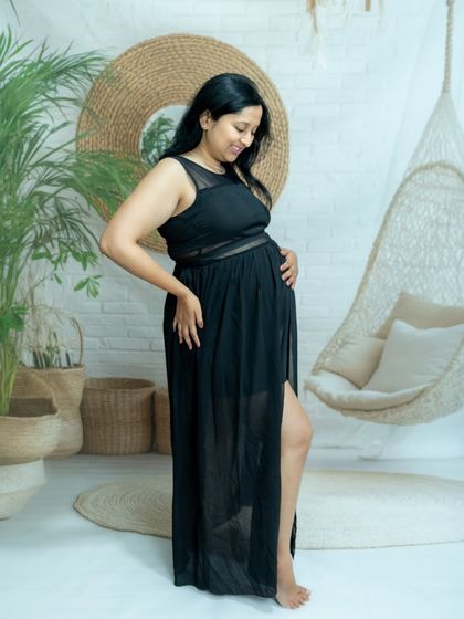 A chic portrait of a mom-to-be in a black dress in our boho studio setup.