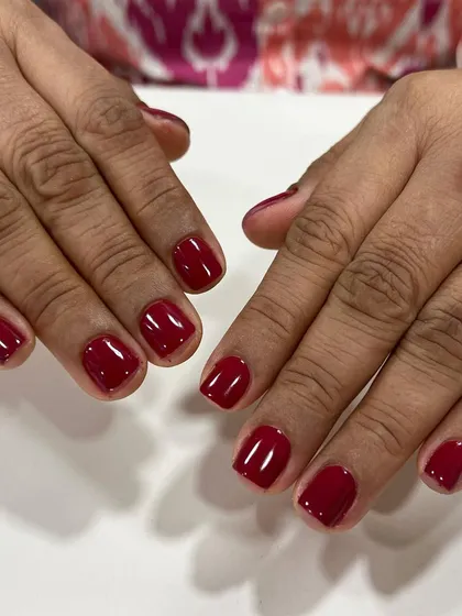 A classic red gel polish on short, square nails. This timeless color is perfect for any occasion and always looks sophisticated.