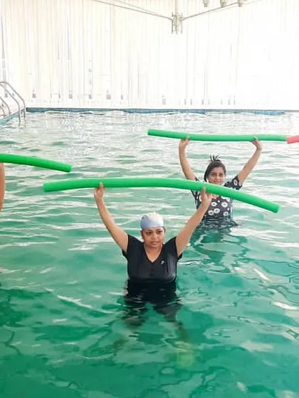 We use a variety of equipment, like these pool noodles, for resistance training. This coordinated group exercise targets the upper body and core, making fitness feel like a team activity.