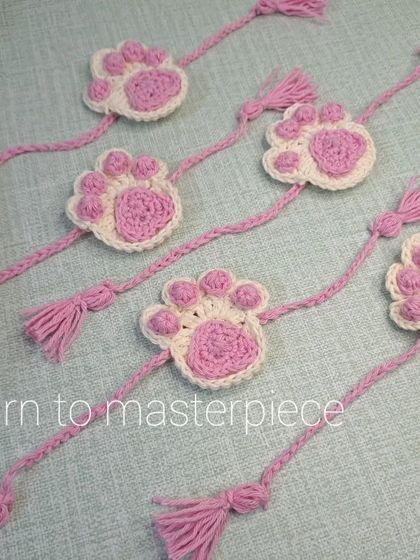For the sibling who loves animals. This is my paw print rakhi, featuring a cute pink and white paw design with braided ties and tassels.