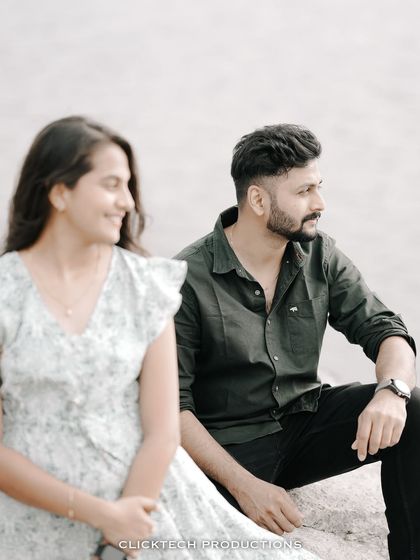 A creative shot using depth of field, with the groom in focus and the bride smiling in the blurred foreground.