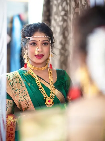 A reflection shot, capturing the model's beauty and the intricacy of her makeup and jewellery.