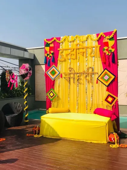 A poolside Haldi seating area with a backdrop featuring the words "Haldi Haath" in Hindi, surrounded by colorful Rajasthani decor.
