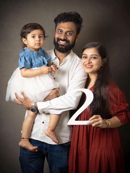 A joyful family portrait celebrating a little one turning two. This classic studio shot is a wonderful way to commemorate yearly milestones.