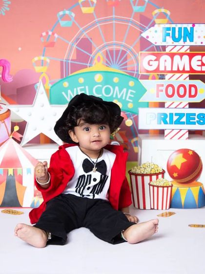 A full view of the exciting carnival theme. This setup is packed with details like a ticket booth, circus tent, and prizes, perfect for a milestone photoshoot.