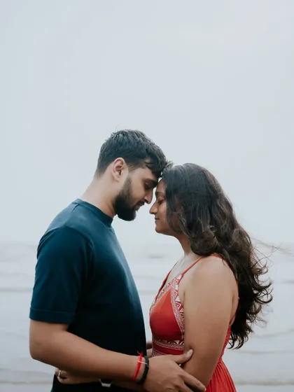 An intimate close-up of a couple with their foreheads touching, captured during their pre-wedding shoot at the beach.