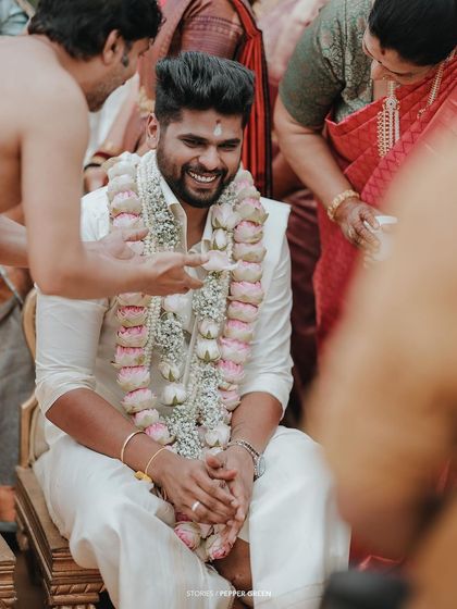 A candid shot of the groom, his face lit up with a happy smile during the ceremony.