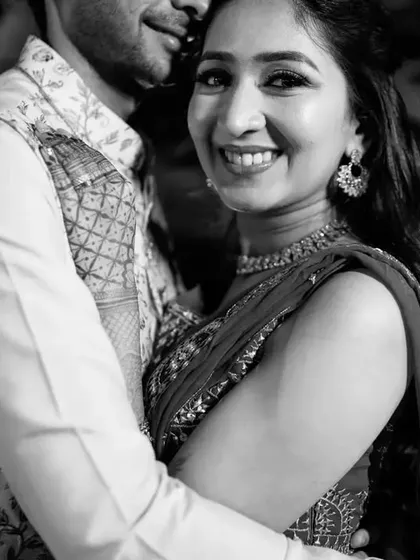 A classic black and white close-up that radiates happiness. Her bright smile is the centerpiece of this photo, capturing a moment of pure joy during their celebration.