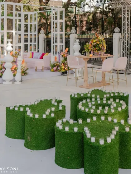 A creative use of greenery, with moss-covered cylinders of varying heights topped with candles to create a unique, organic lighting installation.