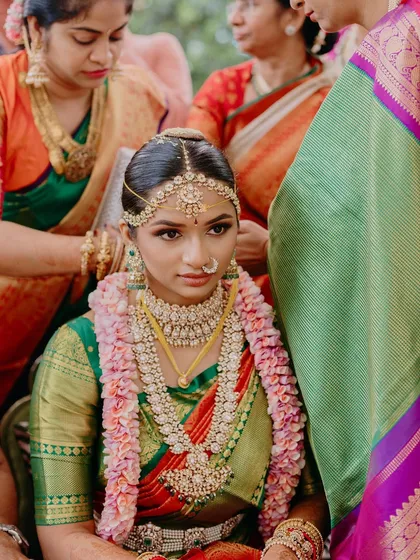 A special moment from a Mahuratham ceremony. The focus is on the bride's serene expression, enhanced by traditional makeup that highlights her eyes and gives her a divine glow.
