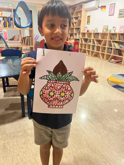 A proud student showing his beautifully decorated 'kalash' craft. Our festival-themed art sessions are a great way to learn about cultural traditions.