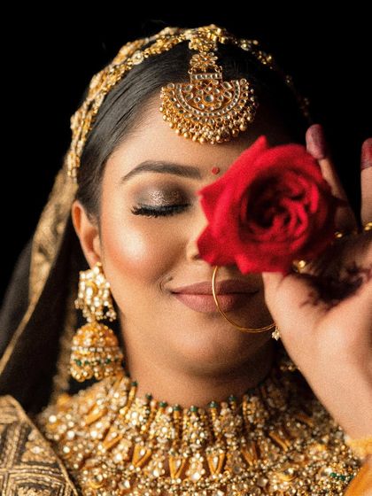 Another angle of the bride with a red rose, showcasing the beautiful smokey eye makeup. This shot captures the artistry of the blended eyeshadow and the radiant glow of the skin.