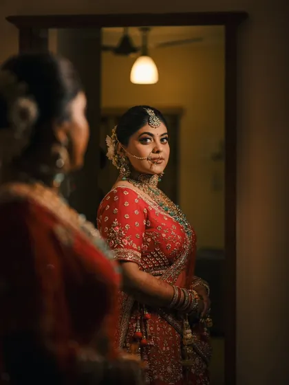 A classic mirror reflection shot. This portrait captures the bride looking at her reflection, creating a moment of quiet contemplation on her big day.